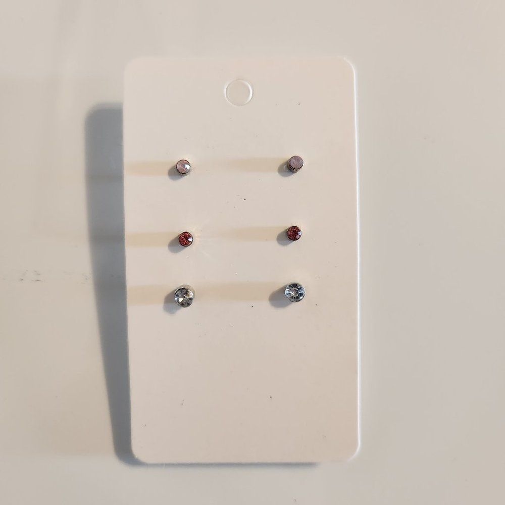 Three pairs of stud earrings pink and blue